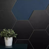 Amsterdam Hexagon Matt Black Porcelain Wall and Floor Tile Wall, with some navy blue wall showing behind