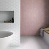 Avatar Matt Rose Pink Hexagon Porcelain Wall and Floor Tile on Bathroom Wall as a feature wall, with the rest of the bathroom walls and floors being the matching white hexagon tile