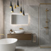 Modern bathroom with grey onyx stone effect tiles, wooden vanity, and freestanding bathtub.
