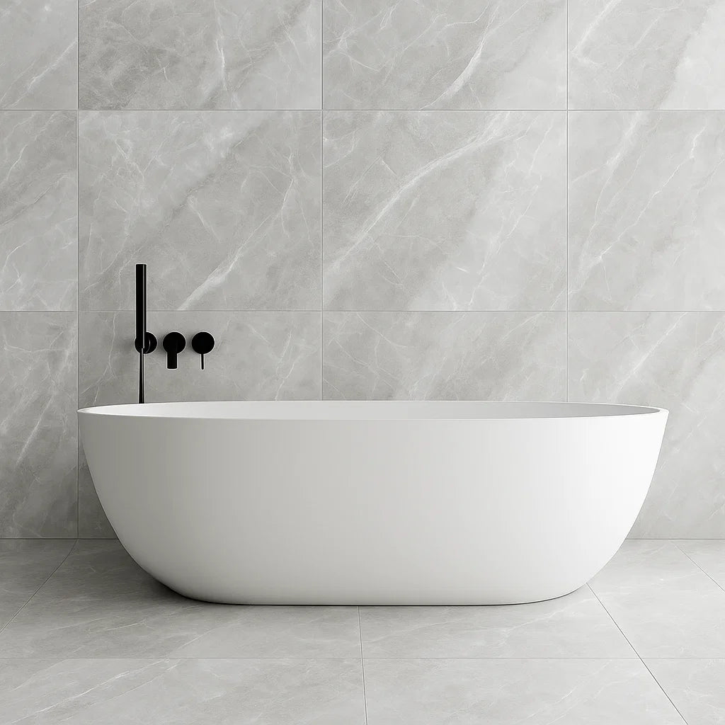 White freestanding bathtub against a grey onyx stone effect tiled wall with black faucet.