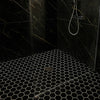 Black tiled shower with black hexagonal patterned tiles and glass enclosure