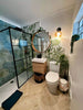 Tropical Forest Green Leaf Pattern Hexagon 333x285 Pattern Wall and Floor Porcelain Tile Customer Photo in Bathroom on one Shower Enclosure Wall, with Tropical Ocean Washed Blue Tile on Other