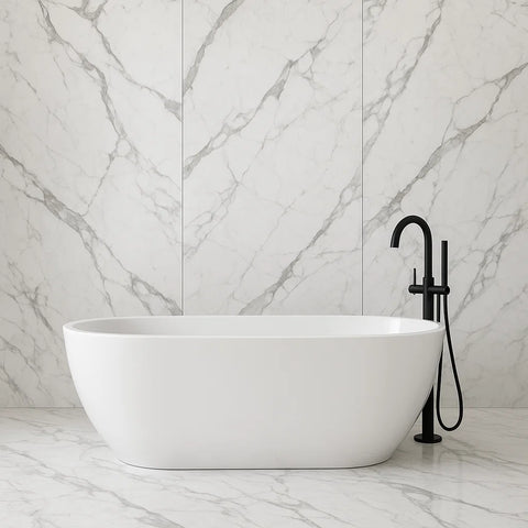 White freestanding bathtub with black faucet against a marble wall.