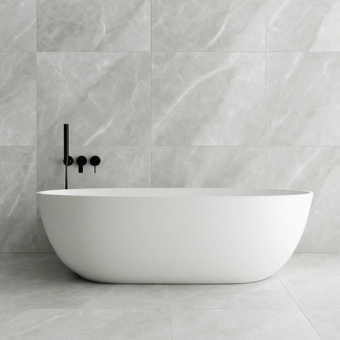White freestanding bathtub against a grey onyx stone effect tiled wall with black faucet.