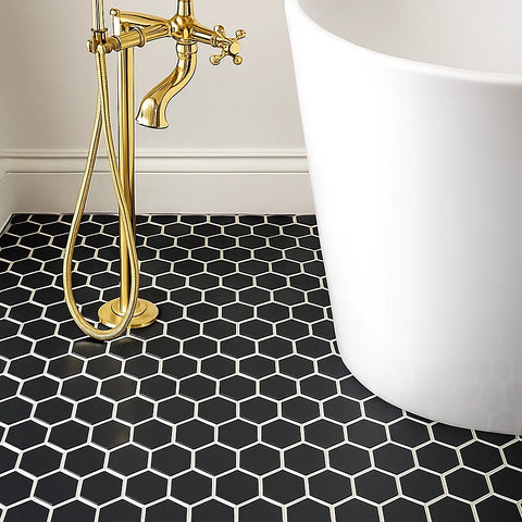 Bathroom with black hexagonal tiles, gold faucet, and white bathtub.