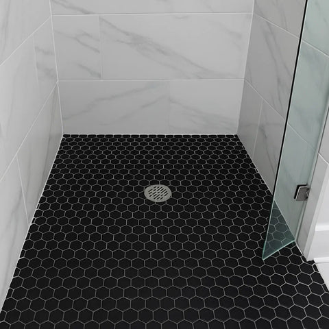 Shower with black hexagonal tiles on the floor and white walls.