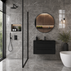 Modern bathroom with grey marble effect tiles, black vanity, and round mirror.