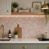 Modern kitchen with hexagonal pink tiles, gold fixtures, and greenery.