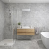 Modern bathroom with grey large format stone effect tiles, wooden vanity, and white fixtures.