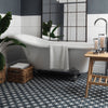 Bathroom with a freestanding bathtub, wooden stool, and decorative elements.